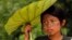 Una niña india sarayaku se cubre del sol en la selva de la amazonia ecuatorial.