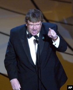 FILE - Michael Moore makes a statement after accepting the Oscar for best documentary feature for the film “Bowling for Columbine” during the 75th annual Academy Awards, March 23, 2003, in Los Angeles.
