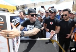 Singers Nicky Jam, Chayanne and Luis Fonsi unload supplies from a JetBlue aircraft at Luis Muñoz Marín International Airport in San Juan, Puerto Rico.