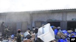 Wanajeshi wa Guinea wakitoa vifaa vya kupigia kura kwenye ghala iliyoungua