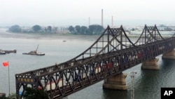 FILE - Trucks cross the friendship bridge connecting China and North Korea in the Chinese border town of Dandong, opposite side of the North Korean town of Sinuiju, Sept. 4, 2017.