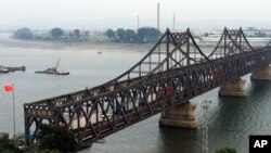 FILE - Trucks cross the friendship bridge connecting China and North Korea in the Chinese border town of Dandong, opposite side of the North Korean town of Sinuiju, Sept. 4, 2017. For Chinese traders, United Nations sanctions on North Korea are a disaster. Business in the Chinese border city of Dandong has all but dried up.