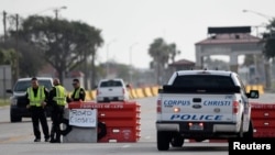Полицейские стоят на контрольно-пропускном пункте после инцидента со стрельбой на базе ВМС Корпус-Кристи, штат Техас, 21 мая 2020 года.