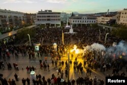 Protesters opposed to against longtime Montenegrin President Milo Djukanovic light flares in Podgorica, Montenegro, March 16, 2019.