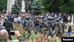 Police officers block opposition supporters during a protest against presidential election, in Almaty, Kazakhstan, June 9, 2019. 