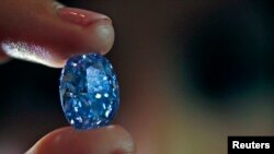 Un employé tenant un diamant bleu de 10.10 carats à la maison de vente aux enchères Sotheby à Londres , le 15 mars 2016.