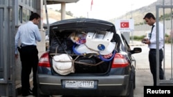 Syrians cross back into Syria at the Turkish Cilvegozu border, opposite the Syrian commercial crossing point Bab al-Hawa, in Reyhanli, Hatay province, May 14, 2013.