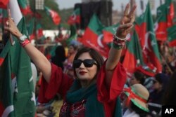 FILE - A supporter of opposition leader Imran Khan's party Tehreek-e-Insaf flashes victory signs during a rally in Lahore, Pakistan, April 29, 2018.