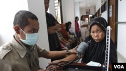 Petugas kesehatan memeriksa tekanan darah seorang pasien lanjut usia di sebuah Puskesmas di Jakarta (foto: dok). 