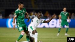 L'attaquant algérien Riyad Mahrez (à gauche) se bat contre l'attaquant sénégalais Sadio Mane lors du match de la Coupe d'Afrique des Nations (CAN) 2019 entre le Sénégal et l'Algérie au Stade du 30 juin au Caire le 27 juin 2019. (Photo de Khaled DESOU