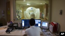 FILE - In this May 19, 2015 file photo, a nuclear medicine technologist makes a PET scan of a patient at Georgetown University Hospital in Washington. Depression has long been linked to certain cognitive problems. (AP Photo/Evan Vucci)