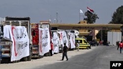Trucks loaded with aid wait at the Rafah border crossing, March 23, 2024. U.N. chief Antonio Guterres said, "Here ... we see the heartbreak and heartlessness of it all. A long line of blocked relief trucks on one side of the gates, the long shadow of starvation on the other."