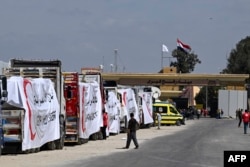 Egyptian Red Crescent trucks loaded with aid queue outside the Rafah border crossing with the Gaza Strip on March 23, 2024.