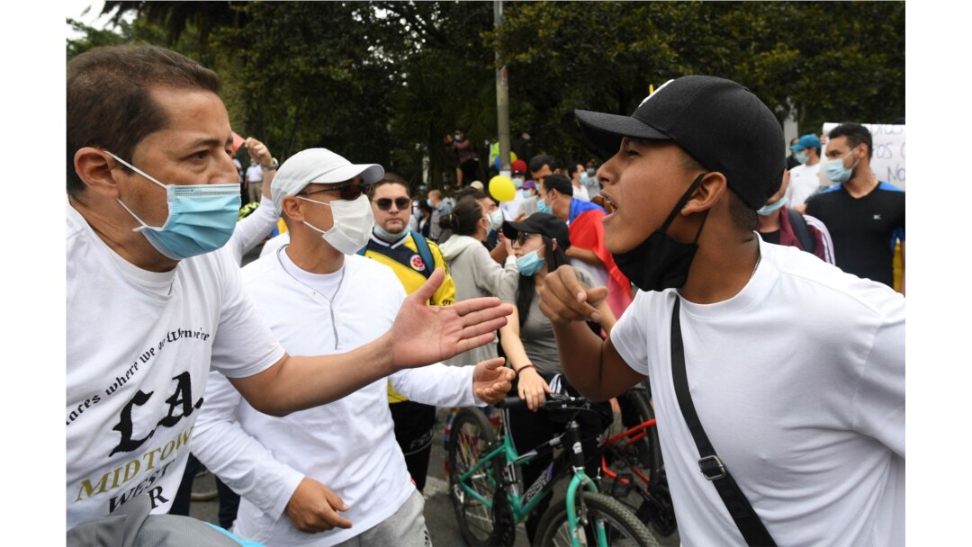 A man (L) against the national strike faces a man who supports it, during a demonstration in opposition to road blockades and violence, after a month of national protests, in Bogota, on May 30, 2021.