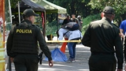 Tim penyidik forensik memeriksa jenazah seorang pria yang tewas setelah sebuah motor yang dilengkapi dengan bom meledak di pos pemeriksaan di komunitas Las Peñas di Jamundi, Kolombia, pada 7 Desember 2024. (Foto: AP/Juan B Diaz)