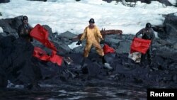 FILE - Crews clean up the oil-soaked beach on Naked Island in the Prince William Sound, on April 2, 1989, after the worst oil spill in U.S. history, cased by the Exxon tanker Valdez. 