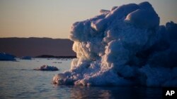 FILE - The suns sets against an iceberg floating in the Nuup Kangerlua Fjord near Nuuk in southwestern Greenland, Aug. 1, 2017. 