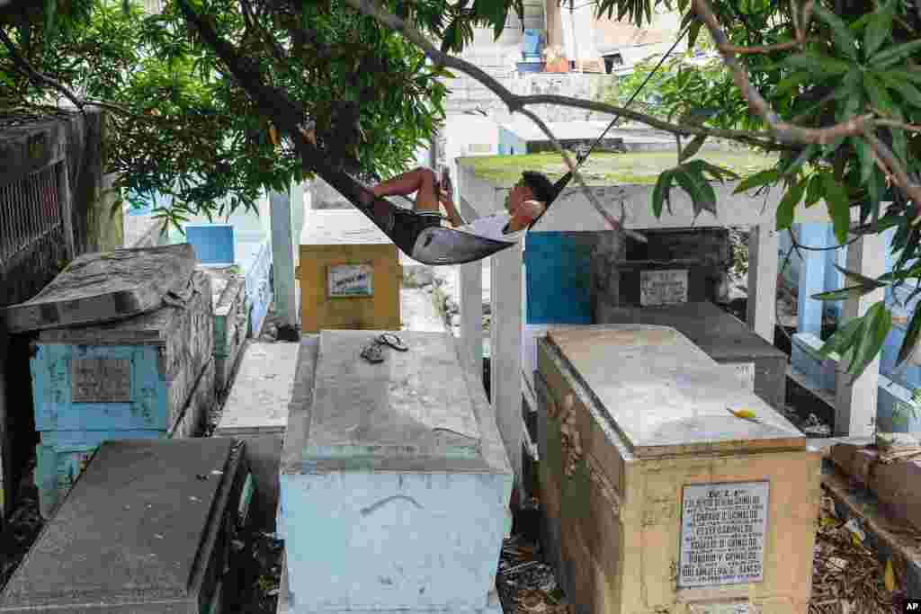 A man who lives inside the North Cemetery relaxes on his hammock on top of tombs in Manila, Philippines.