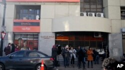 Periodistas esperan a las afueras de la Conferencia Episcopal de Santiago después de que las autoridades allanaran el edificio el martes, 14 de agosto del 2018. 