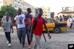 FILE - Students cross the street outside the Yavuz Selim school in Dakar, Senegal, Oct. 2, 2017.