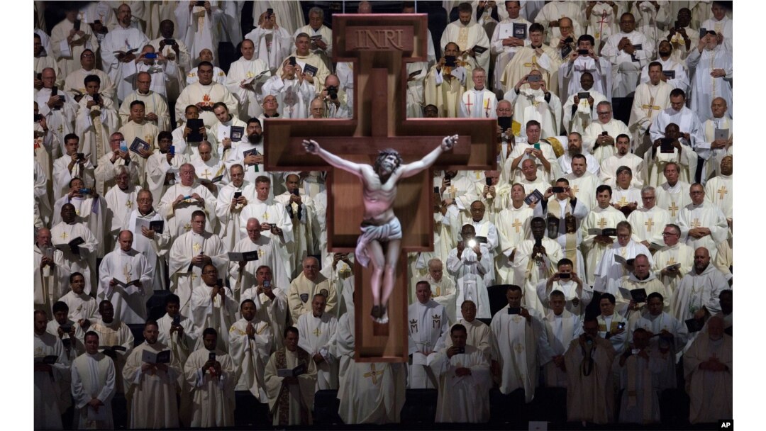 A crucifix hangs above member of the clergy who watch as Pope Francis, not shown, celebrates Mass at Madison Square Garden, New York, Sept. 25, 2015.