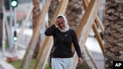 A woman cries asking for her son as she walk near the scene of an attack after a truck drove onto the sidewalk and plowed through a crowd of revelers who'd gathered to watch the fireworks in the French resort city of Nice, southern France, Friday, July 15