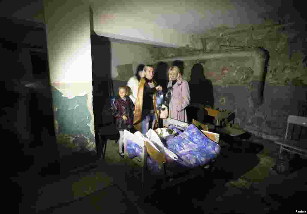 Parents and a student hide in a school basement used as a shelter after recent shelling in Donetsk, eastern Ukraine, Oct. 1, 2014.