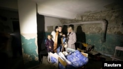 1일 우크라이나 동부 도네츠크 학교에 포탄에 날아든 후, 학생과 학부모들이 지하로 피신했다.