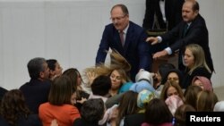 Ruling AK Party and opposition lawmakers scuffle after the independent lawmaker Aylin Nazliaka (not pictured) handcuffed herself to the rostrum during a debate to protest against proposed constitutional changes at the Turkish Parliament in Ankara, Jan. 19, 2017.