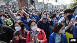 14일 한국 서울에서 마스크를 착용한 시민들이 더불어민주당 이낙연 상임공동선대위원장의 선거 유세 집회에 참석했다. 