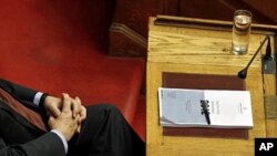 Greek PM Lucas Papademos attends a parliament session with a copy of Greece's 2012 budget placed on his desk in Athens, November 18, 2011