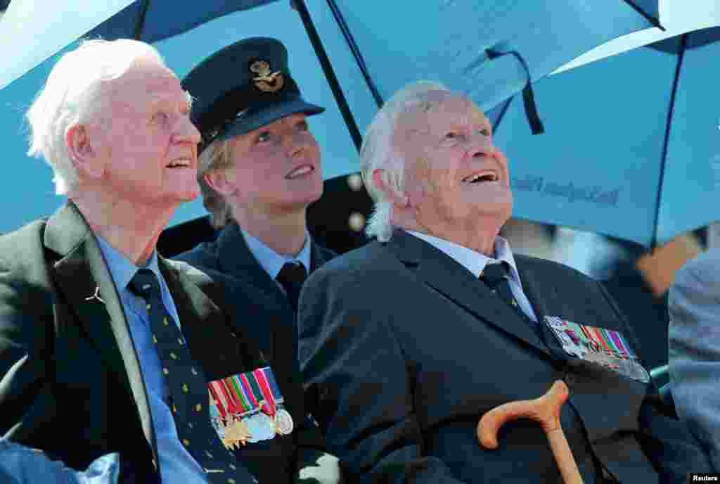 Battle of Britain veterans Wing Commander TF Neil (L), and Geoffrey Harris Augustus Wellum watch a RAF airplane fly over Buckingham Palace to mark the 75th anniversary of the Battle of Britain, in London.