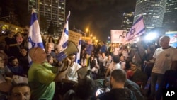 Israeli protesters hold flags and chant slogans during a demonstration against the cease-fire between Israel and Gaza's Hamas in Tel Aviv, Israel, Thursday, Nov. 15, 2018.