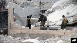 Iraqi security forces, supported by U.S.-led coalition airstrikes, advance their position through damaged buildings towards the central Ramadi, 115 kilometers (70 miles) west of Baghdad, Iraq, Dec. 24, 2015. 