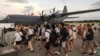 A handout photo taken on Dec. 21, 2024 and received from the Australian Department Foreign Affairs and Trade shows Australian Defense Forces helping Australians off a C-130J Hercules at Brisbane Airport after an earthquake struck Port Vila, Vanuatu. 