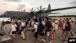 A handout photo taken on Dec. 21, 2024 and received from the Australian Department Foreign Affairs and Trade shows Australian Defense Forces helping Australians off a C-130J Hercules at Brisbane Airport after an earthquake struck Port Vila, Vanuatu. 