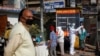 A healthcare worker wearing personal protective equipment (PPE) collects a swab sample from a man, amidst the spread of the coronavirus disease (COVID-19), at market area in the old quarters of Delhi, India, Dec. 19, 2020. 