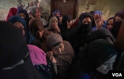 Women crowd into a local charity to receive a food aid in Cairo, April 21, 2020. (Hamada Elrasam/VOA)