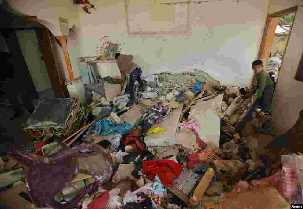 Palestinian children inspect a house that witnesses said was damaged in an Israeli strike in the central Gaza Strip, Dec. 25, 2013. 