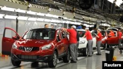 FILE - A worker is seen completing final checks on the production line at Nissan car plant in Sunderland, northern England, June 24, 2010. 