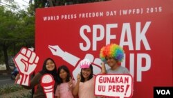 Warga Jakarta berfoto di depan dinding kampanye peringatan Hari Pers Sedunia 2015, Minggu, 3 Mei 2015, di Taman Menteng Jakarta. (VOA/Andylala)