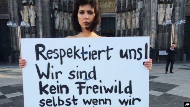 La artista suiza Milo Moire protesta desnuda frente a la Catedral de Colonia, en el occidente de Alemania, con un cartel que dice "Respétennos! No somos caza legal, incluso cuando estamos desnudas!!!".  La policía de la ciudad alemana ha recibido al menos 170 denuncias de asaltos sexuales y robos durante la pasada Nochebuena. Enero 8 de 2016.