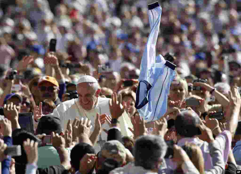 Paus Fransiskus menyapa umat saat tiba di alun-alun Santo Petrus di Vatikan untuk audiensi mingguan (18/9). (AP/Riccardo De Luca)