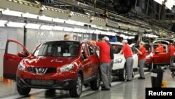 FILE - A worker is seen completing final checks on the production line at Nissan car plant in Sunderland, northern England, June 24, 2010. 