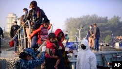 FILE - Rohingya refugees board a naval ship to be transported to an isolated island in the Bay of Bengal, in Chittagong, Bangladesh, Dec. 29, 2020.