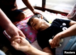 Jitsuko Tanaka, 64, one of the first people to be officially recognized as victims of Minamata disease, is being comforted by her sister and brother-in-law at her home in Minamata, Kumamoto Prefecture, Japan, Sept. 12, 2017.