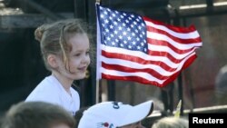 A young supporter flies a U.S. flag Feb. 28, 2016, at a rally in in Madison, Alabama, during the presidential candidates' final push to Super Tuesday.