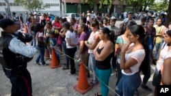 FILE - Relatives of prisoners wait to hear news about their family members imprisoned at a police station where a riot broke out, in Valencia, Venezuela, March 29, 2018.