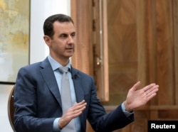 FILE - Syria's President Bashar al-Assad is interviewed Feb. 10, 2017, in Syria. Thousands of Afghans from Iran are involved in the Syrian conflict, many sent against their will, Human Rights Watch reports.