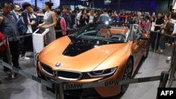 People look at a BMW i8 electric car during the first public opening day the Beijing auto show 